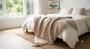 Woven neutral accent blanket layered across the foot of a queen bed for cozy bedroom home decor.