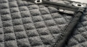 Close-up view of the reinforced stitching and heavy-duty quilted padding on a professional soundproof moving blanket.