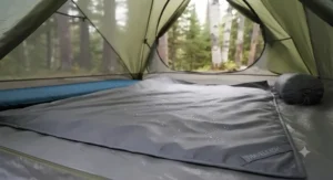 Lightweight and compact travel blanket draped over a backpack during a hike in the Canadian Rockies.
