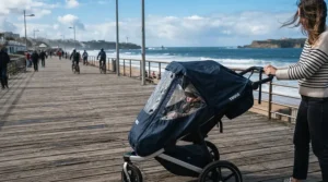 A baby protected from cold gusts by one of the best stroller blankets for babies equipped with a windproof lining
