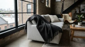 A dark, wrinkle resistant photography backdrop blanket draped over furniture in a Toronto creator space.